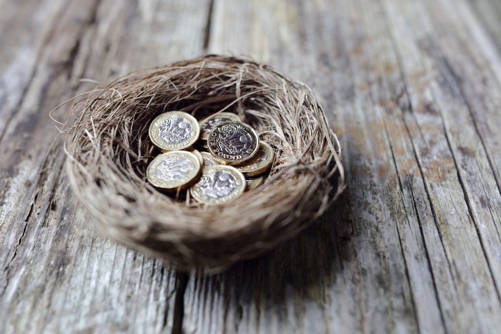 Retirement savings British pound coins in birds nest egg